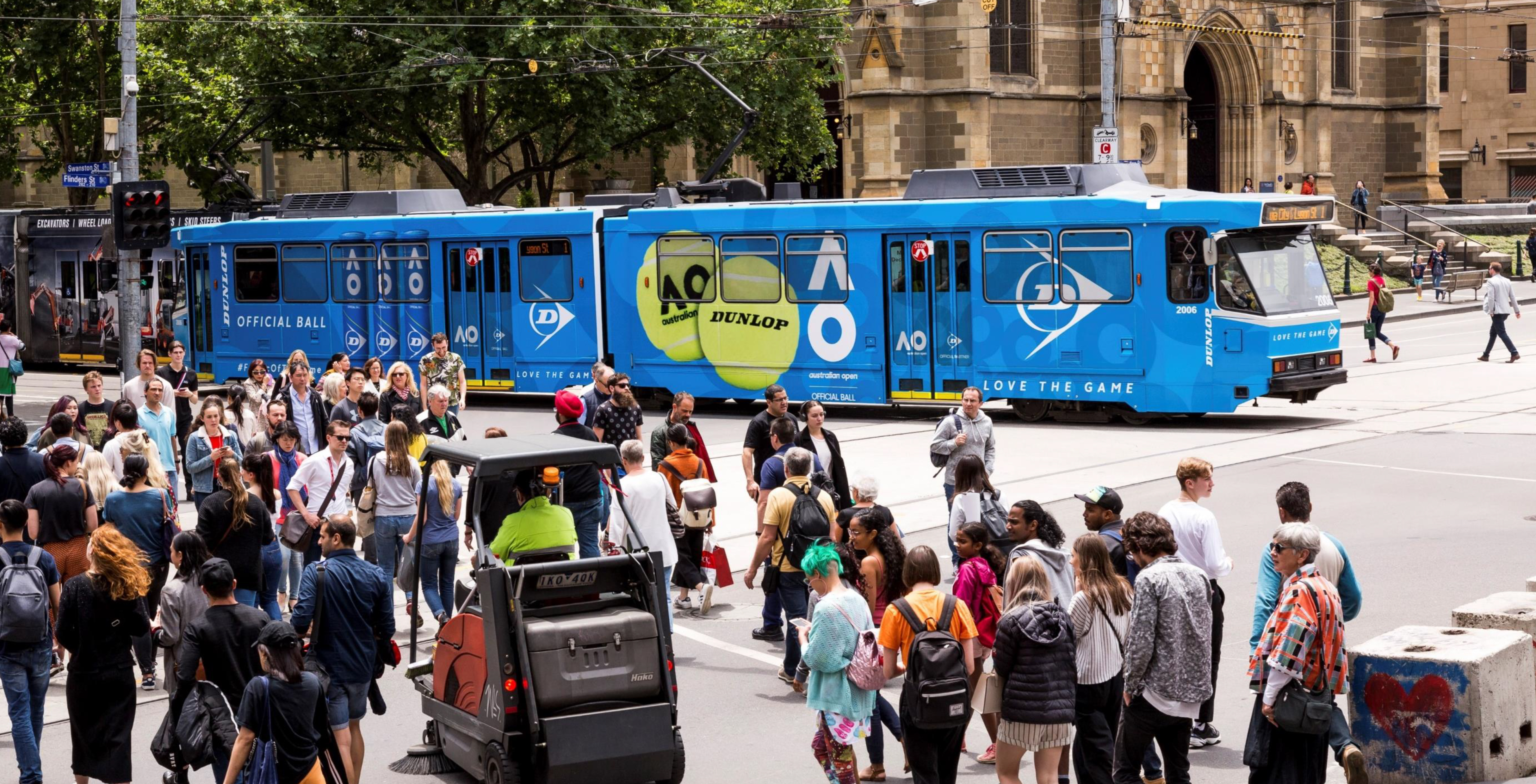 Dunlop Australian Open branded tram moving through Melbourne city crowds